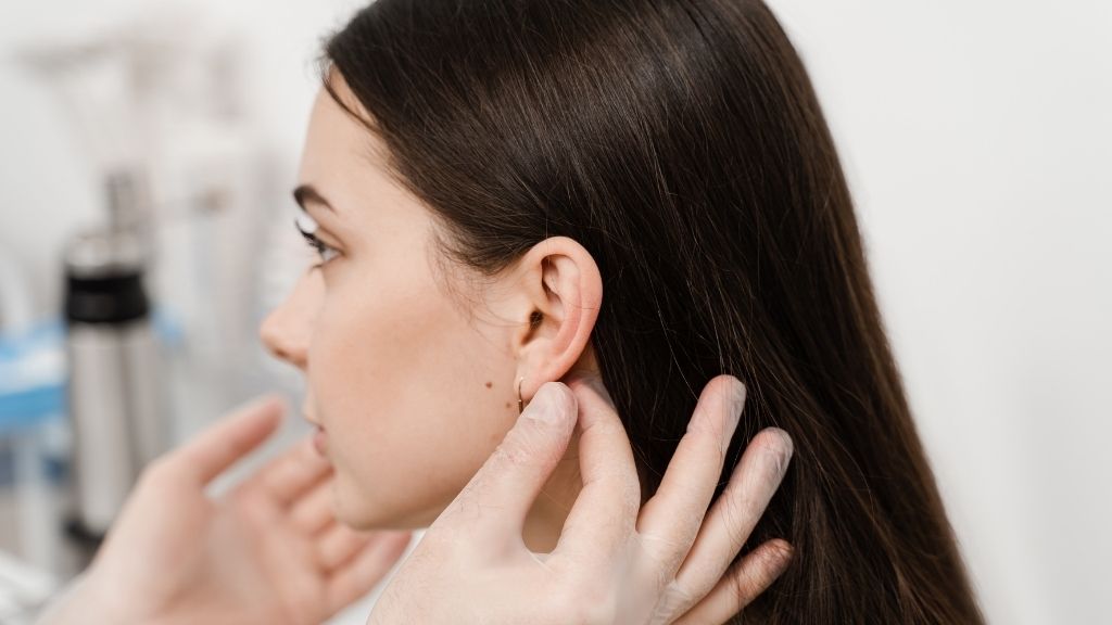 Valoración de la forma de la oreja de una paciente en una consulta de otoplastia